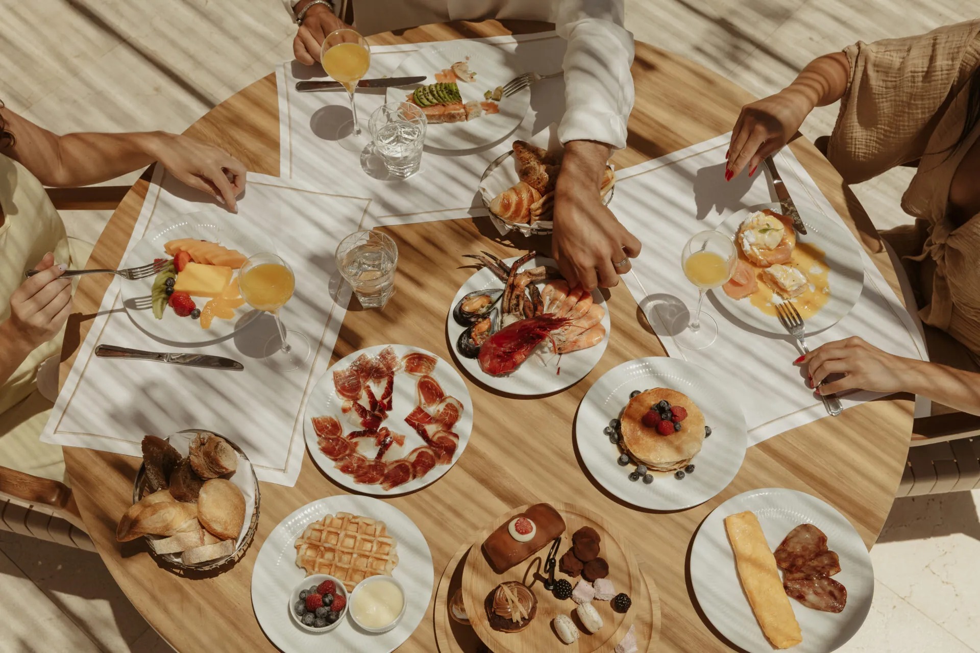 Mesa preparada para compartir platos, postres y bebidas de la barra
